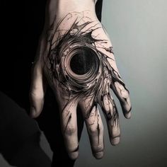 a person's hand with a black and white tattoo on it