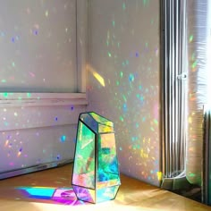 a vase sitting on the floor in front of a window with light shining through it