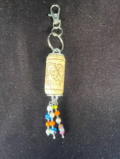 a keychain with beads and a chain attached to it on a black surface