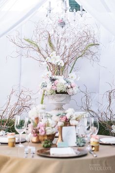 the table is set with white and pink flowers