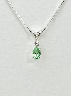 Light oval green cubic zirconia measures 6x4mm (1/2 carat). Tiny white accent cubic zirconia. Both stones were handset in sterling silver. Sterling silver box chain is 18 inches long and can be switched to a 16 inch chain upon request. Necklace is perfect for a child or the minimalist. Comes in a gift box Green Cubic Zirconia Emerald Necklace, Fine Jewelry, Green Cubic Zirconia Emerald Necklace In Fine Jewelry Style, Green Cubic Zirconia Emerald Necklace, Green Emerald Gemstone Necklace In Cubic Zirconia, Green Sterling Silver Birthstone Pendant Necklace, Green Sterling Silver Pendant Birthstone Necklace, Green Pendant Birthstone Necklace In Sterling Silver, Green Solitaire Necklace For May Birthstone Gift, Green Cubic Zirconia Emerald Necklace Birthstone