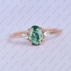 an oval cut green tourmaline and diamond ring with three stones on each side