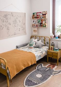 a bed room with a neatly made bed next to a window