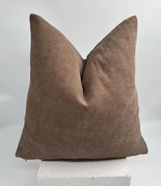 a brown pillow sitting on top of a white block