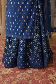 Editor's Note Zardozi Embroidered Chanderi Brocade Kurta With Gold Butis Georgette Skirt Set Color: Blue Fabric: Chanderi Brocade , Georgette & Net Embroidery Details: Zardozi Care: Dry... Traditional Wedding Skirt With Intricate Embroidery, Fitted Floral Embroidery Sharara For Traditional Ceremonies, Traditional Embroidered Long Skirt Set, Traditional Fitted Skirt With Resham Embroidery, Fitted Traditional Skirt With Resham Embroidery, Traditional Embroidered Long Lehenga, Diwali Sharara With Zari Work And Tiered Skirt, Traditional Long Skirt With Resham Embroidery, Traditional Resham Embroidered Skirt