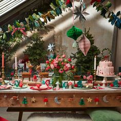 a table covered with lots of food and decorations on top of wooden tables next to christmas trees