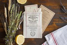 some lemons and herbs are sitting on a table next to an envelope with the same label