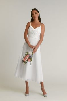 a woman in a white dress holding a bouquet