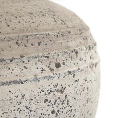 a close up view of a vase on a white surface with black speckles