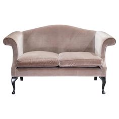 a beige velvet couch with black legs and back rests on an isolated white background,