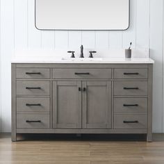 a bathroom vanity with two sinks and a large mirror above it on a white wall