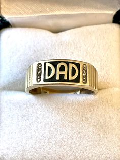 This is a wonderfully beautiful ring that spells "DAD" . A small diamond flanks each side of DAD. Vintage, Dad is highly polished with a black enamel background. Inside is marked 10kt  and DB.   Size 10 1/2 . Perfect gift for a DAD. Weighs 3  grams. This ring is in excellent condition and can be resized up or down a size by any good jeweler.  Ships for free with tracking. Personalized Engraved Yellow Gold Ring For Collectors, Personalized Yellow Gold Signet Ring Collectible, Vintage Personalized Jewelry For Father's Day, Personalized Vintage Jewelry For Father's Day, Antique Personalized Signet Ring For Anniversary, Personalized Antique 14k Gold Rings, Antique 14k Gold Signet Ring With Diamond Accents, Collectible Gold Rings With Diamond Accents, Engraved 14k Gold Ring With Diamond Accents For Gift