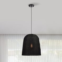 a black lamp hanging from the ceiling in front of a window