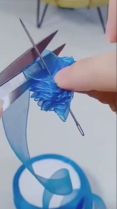 someone using scissors to cut something blue