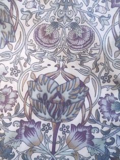 an intricately designed wallpaper with flowers and leaves in blue, purple and white colors