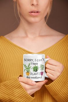 a woman is holding a coffee mug with plants on it and the words sorry, i can't i have plant this weekend