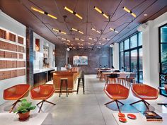 an empty restaurant with lots of chairs and lights hanging from the ceiling, along with bar stools