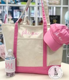 a pink and white tote bag sitting on top of a table next to a water bottle