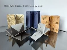 four folded books sitting on top of a table next to each other with the words, heil kle blizzard book step by step