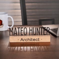 a wooden sign that reads mateo hunter on it next to a laptop and coffee mug