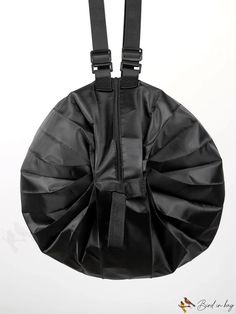 a black round bag with straps hanging from it's back end, on a white background