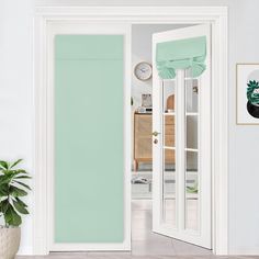 an open door in a white room with green curtains on the windowsill and a potted plant next to it