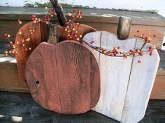 two wooden pumpkins sitting next to each other