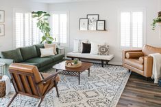 a living room with couches, chairs and rugs on the hardwood flooring