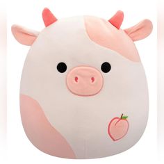 a white and pink pig pillow with an apple on it