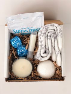 an open box containing candles, soaps and other items