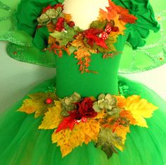 a green dress with leaves and flowers on it