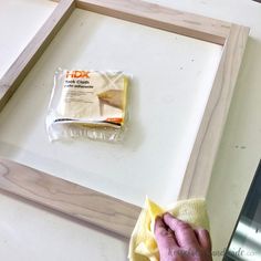 a person wiping up some food on a table with a cloth and sponges in front of it