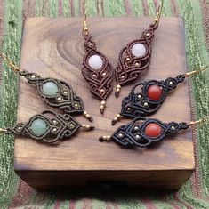 four pieces of beaded jewelry sitting on top of a wooden box