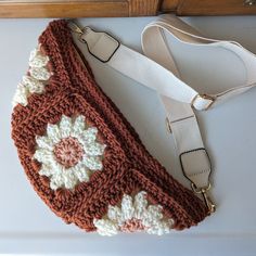 a crocheted purse sitting on top of a white table next to a wooden drawer