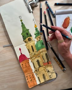 a person is drawing with colored pencils on paper