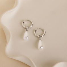 Introducing our Pearl Teardrop Huggies, featuring dainty hoop earrings with lustrous pearls that gracefully dangle. These earrings are the perfect accessory for a beach wedding, offering a timeless elegance that complements any bridal look. Embrace the romance of the seaside and add a touch of coastal charm to your special day with these delicate earrings. SKU: RR-ER522 Product Details Material: High Quality Solid 925 Sterling Silver Finish: 18K Gold ∙ Sterling Silver Hoop Dimensions: ~8mm Inner Silver Hoop Earrings With Pearl Charm For Wedding, White Drop Hoop Earrings, White Gold Dangle Hoop Earrings For Wedding, White Pearl Charm Hoop Earrings For Wedding, White Hoop Earrings With Pearl Charm For Wedding, Delicate White Hoop Earrings With Pearl Drop, Minimalist Hoop Earrings With Pearl Chain For Wedding, Minimalist Pearl Chain Hoop Earrings For Wedding, Minimalist Wedding Hoop Earrings With Pearl Chain