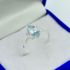 a ring with an aqua blue topaz sits in a box