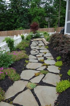 a stone path in the middle of a garden