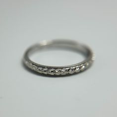 This Vintage-Inspired 18K White Gold Band Ring exudes timeless elegance with its intricate leaf motif, delicately etched around the entire band. The milgrain detailing along the edges adds a refined touch, enhancing the ring's vintage charm. Measuring 2.2mm in width, this size 4.5 ring is a slender yet eye-catching piece that can be worn alone or stacked with other rings for a personalized look. Weighing 1.54 grams, it is lightweight and comfortable for everyday wear. This ring is perfect for those who appreciate classic design with a touch of nature-inspired artistry, making it a meaningful addition to any jewelry collection. Ringe Gold, Leaf Motif, Gold Band Ring, White Gold Band, Gold Band, Vintage Charms, Wedding Shop, Band Ring, Vintage Rings