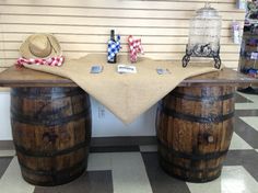 there is a table with two wine barrels and a cowboy hat on the table top