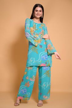 Dark turquoise kurta with floral print and placement embroidery. Paired with printed pant.
Components: 2
Pattern: Printed,Embroidered
Type Of Work: Floral
Neckline: Round
Sleeve Type: Bell
Fabric: Georgette, Shantoon
Color: Blue
Other Details: 
Floral print
Occasion: Mehendi and Haldi - Aza Fashions Floral Print Straight Kurta Pant Set For Eid, Designer Silk Sets With Floral Print, Bollywood Style Summer Floral Sets, Unstitched Traditional Pant Set With Floral Print, Festive Floral Print Unstitched Pant Set, Traditional Floral Print Pant Set For Eid, Bollywood Style Silk Sets With Floral Print, Blue Silk Kurta With Floral Print, Elegant Georgette Palazzo Set With Floral Print