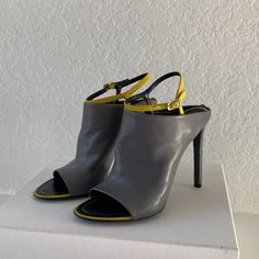 Balenciaga High Heel Peep Toe Sandals In Soft Gray Leather With Yellow Detailing. Never Worn And In Original Packaging. French Size 39.5, Equaling 8.5/9 Us Women's Size. Designer Yellow Sandals With Ankle Strap, Yellow Pointed Toe Evening Sandals, Yellow Closed Toe Sandals For Formal Occasions, Formal Yellow Closed Toe Sandals, Designer Yellow High Heel Sandals, Yellow Slingback Heels For Party, Designer Heels For Spring Workwear, Yellow Fitted Ankle Strap Heels, Yellow Fitted Sandals For Evening