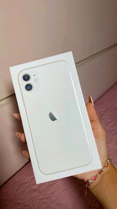 a person holding an iphone 11 in their hand, with the box on it's side