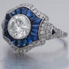 "𝐃𝐞𝐬𝐜𝐫𝐢𝐩𝐭𝐢𝐨𝐧 : *Antique Filigree Ring, Round With Blue Sapphire Baguette Cut CZ Diamond Ring, Gold Or Wedding Ring, Gift For Mother, Edwardian Retro Ring. ❖ 𝐃𝐢𝐚𝐦𝐨𝐧𝐝 𝐃𝐞𝐭𝐚𝐢𝐥𝐬 *Color : White, Blue *Clarity : VVS *Cut : Excellent *Center Stone Shape : Round Cut *Center Stone Size : 7.00 MM *Center Stone Weight : 1.33 CT *Type : Cubic Zirconia (CZ) *We have all types of fancy & color Gemstone. For more queries please contact us immediately. ❖ 𝐑𝐢𝐧𝐠 𝐃𝐞𝐭𝐚𝐢𝐥𝐬 *Metal Purity : Solid Gold (10K, 14K, 18K); 925 Sterling Silver *Stamp : Yes (As per metal purity) *SKU : SR4186 *Making Process : Handmade > Crafted by our experienced craftsman. ❖ 𝐂𝐮𝐬𝐭𝐨𝐦𝐢𝐳𝐚𝐭𝐢𝐨𝐧 *Buyer can Request change of rhodium color in 925 Silver Jewelry (No additional Charges). *In Gold ( Luxury Intaglio Sapphire Ring For Anniversary, Blue Platinum Art Deco Diamond Ring, Art Deco Blue Diamond Ring, Blue Diamond Art Deco Ring, Blue Art Deco Diamond Ring, Art Deco Blue Diamond Ring With Center Stone, Blue Art Deco Diamond Ring With Center Stone, Art Deco Blue Platinum Ring, Art Deco Blue Sapphire Ring With Center Stone