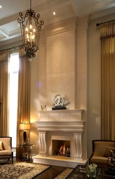 a living room filled with furniture and a fire place under a chandelier hanging from the ceiling