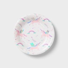 a white paper plate with unicorns and rainbows on the rim, against a gray background