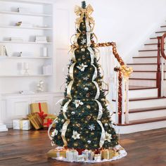 a decorated christmas tree in the middle of a living room with presents on the floor