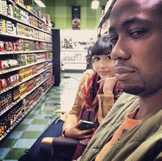 two people sitting in a store looking at their cell phones