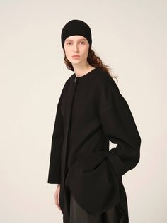 Tulip-shaped, sculpted, drop-shoulder, collar-less coat in felted wool. Both models are wearing a size S. Modern Fall Outerwear With Structured Shoulders, Avant-garde Long Coat For Workwear, Modern Outerwear With Structured Boning, Modern Structured Outerwear With Boning, Modern Long Sleeve Outerwear With Structured Boning, Fall Outerwear With Structured Shoulders, Modern Structured Outerwear, Modern Structured Wool Coat, Fall Outerwear With Structured Shoulders And Long Sleeves