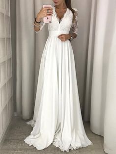 a woman taking a selfie wearing a white wedding dress and holding a cell phone